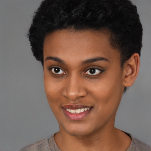 Joyful black young-adult female with short  brown hair and brown eyes