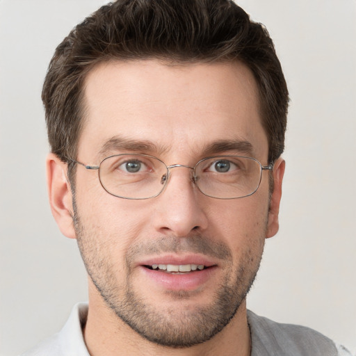 Joyful white adult male with short  brown hair and grey eyes