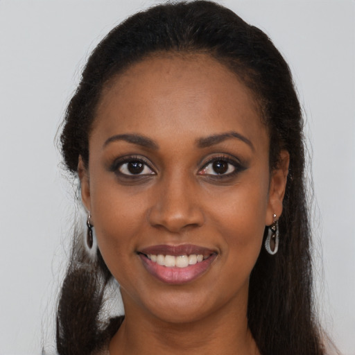 Joyful black young-adult female with long  brown hair and brown eyes
