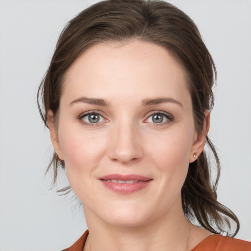 Joyful white young-adult female with medium  brown hair and grey eyes