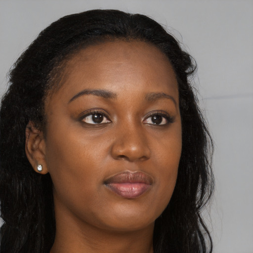 Joyful black young-adult female with long  brown hair and brown eyes