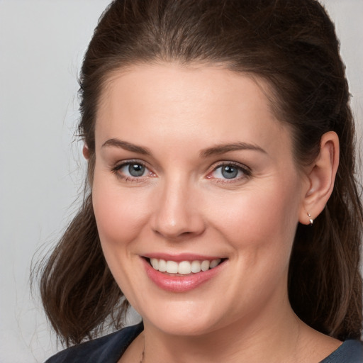 Joyful white young-adult female with medium  brown hair and grey eyes