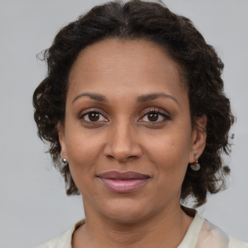 Joyful latino adult female with medium  brown hair and brown eyes