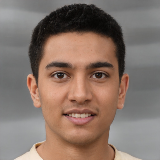 Joyful latino young-adult male with short  brown hair and brown eyes