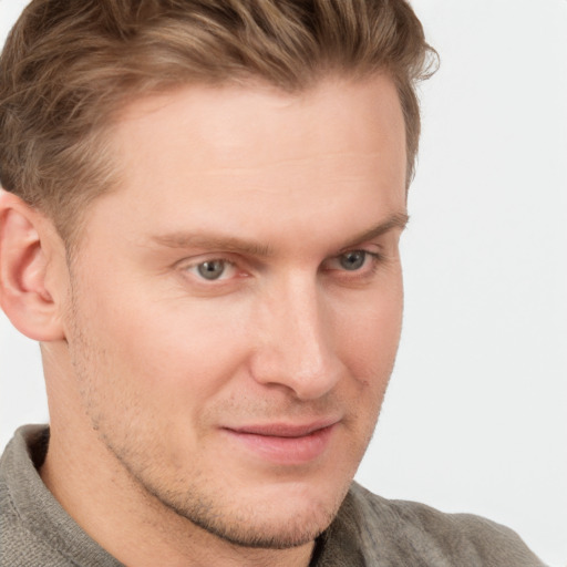 Joyful white young-adult male with short  brown hair and blue eyes