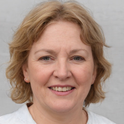 Joyful white adult female with medium  brown hair and blue eyes