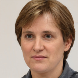 Joyful white adult female with medium  brown hair and grey eyes