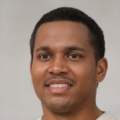Joyful black young-adult male with short  black hair and brown eyes