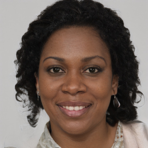 Joyful black adult female with long  brown hair and brown eyes