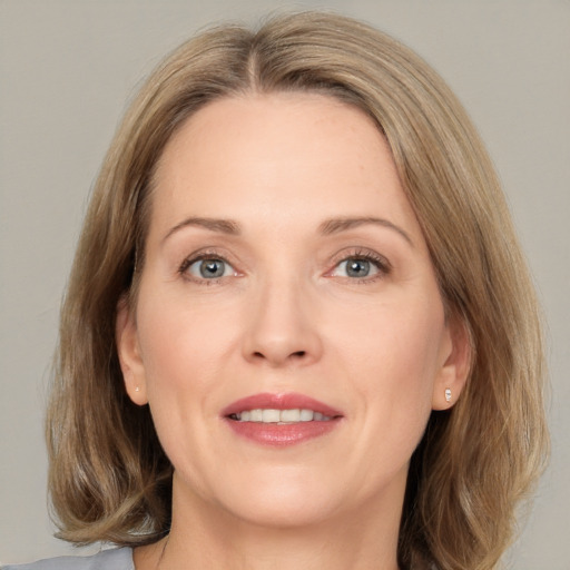 Joyful white adult female with medium  brown hair and green eyes