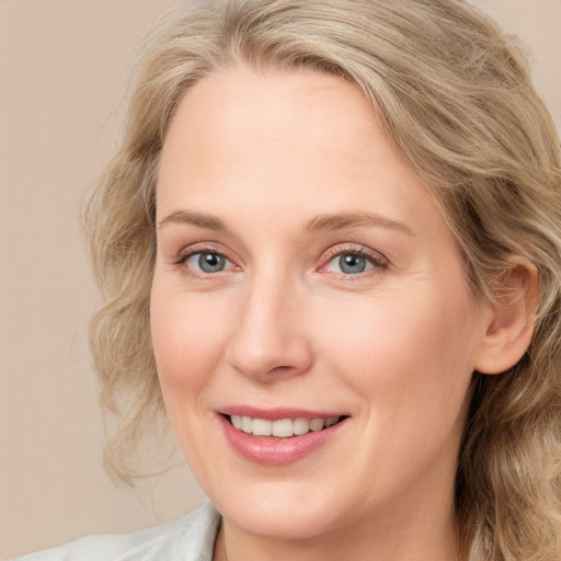 Joyful white adult female with medium  brown hair and blue eyes