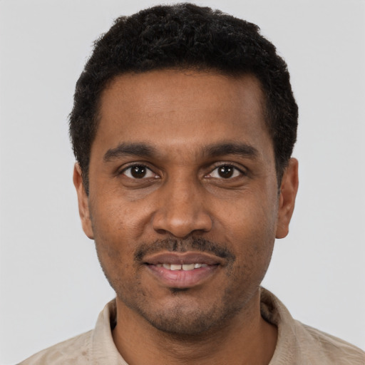 Joyful black young-adult male with short  black hair and brown eyes