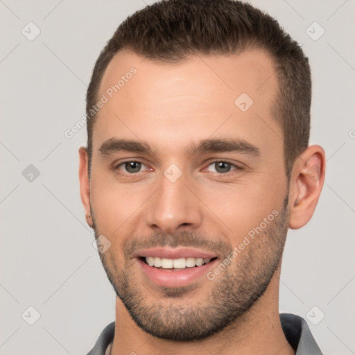 Joyful white young-adult male with short  brown hair and brown eyes