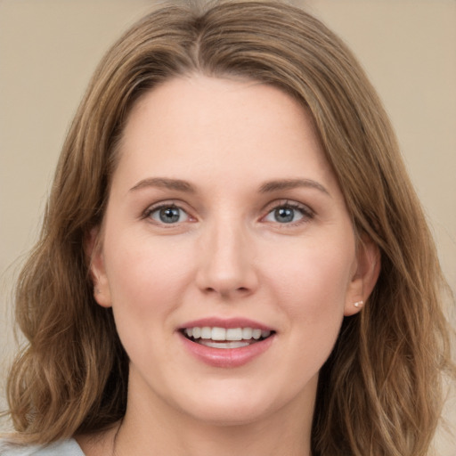 Joyful white young-adult female with long  brown hair and grey eyes