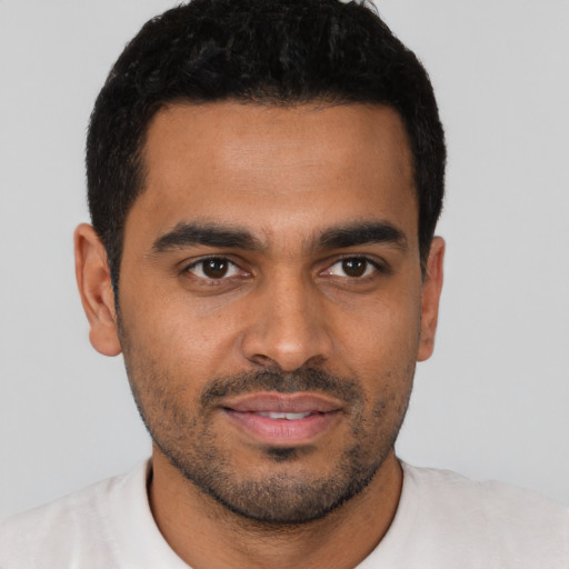 Joyful latino young-adult male with short  black hair and brown eyes