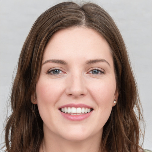 Joyful white young-adult female with long  brown hair and grey eyes