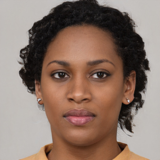 Joyful black young-adult female with short  black hair and brown eyes