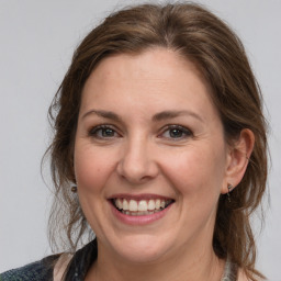 Joyful white adult female with medium  brown hair and grey eyes