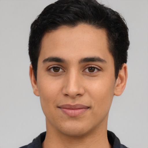 Joyful latino young-adult male with short  brown hair and brown eyes