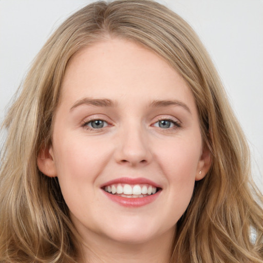 Joyful white young-adult female with long  brown hair and blue eyes