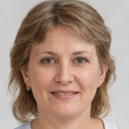 Joyful white adult female with medium  brown hair and grey eyes