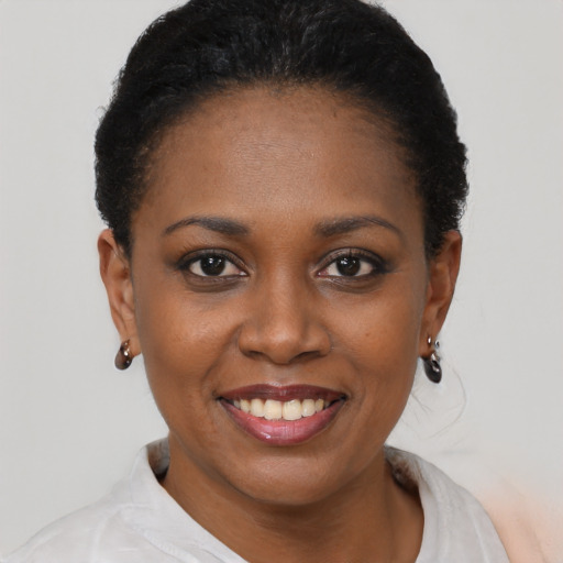 Joyful black young-adult female with short  black hair and brown eyes