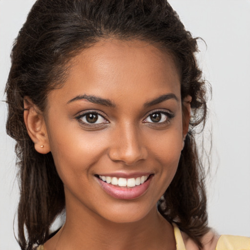 Joyful black young-adult female with medium  brown hair and brown eyes