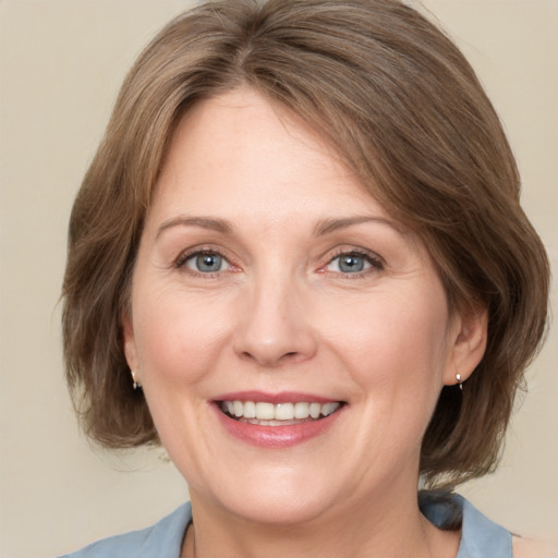 Joyful white adult female with medium  brown hair and grey eyes