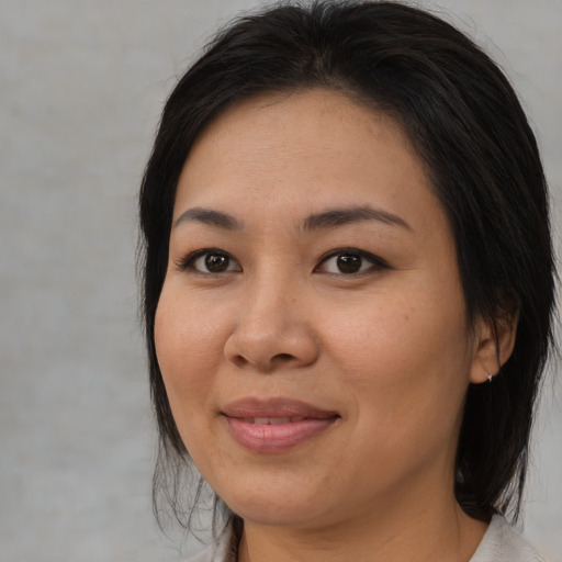 Joyful asian adult female with medium  brown hair and brown eyes