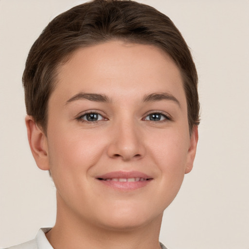 Joyful white young-adult female with short  brown hair and grey eyes