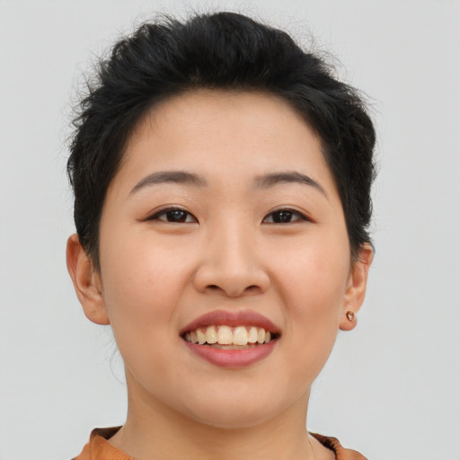 Joyful asian young-adult female with short  brown hair and brown eyes