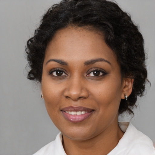 Joyful black young-adult female with medium  brown hair and brown eyes