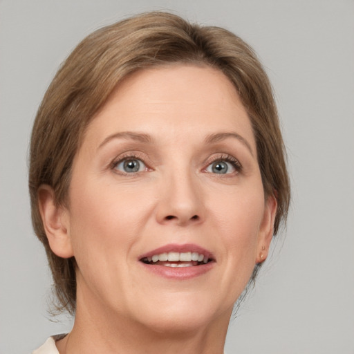 Joyful white adult female with medium  brown hair and grey eyes