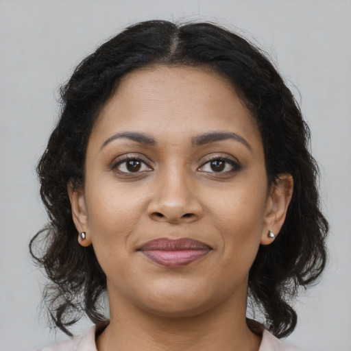 Joyful black young-adult female with long  brown hair and brown eyes