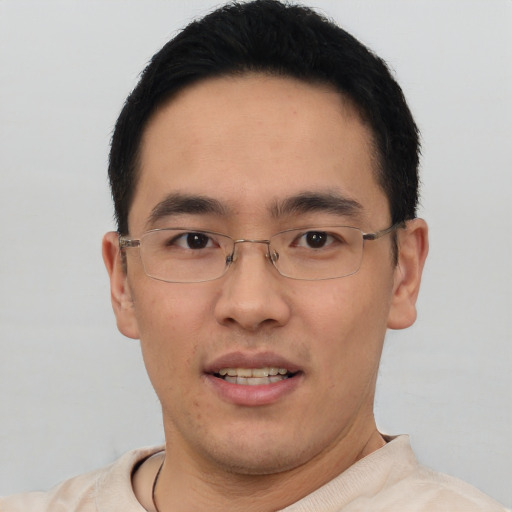 Joyful asian young-adult male with short  black hair and brown eyes