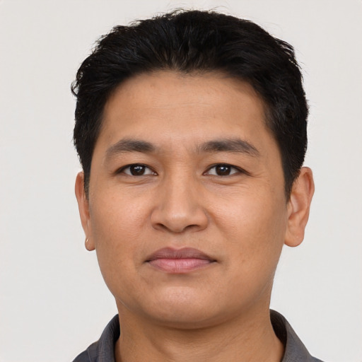 Joyful asian young-adult male with short  black hair and brown eyes