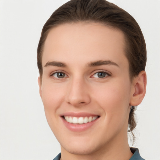 Joyful white young-adult female with short  brown hair and grey eyes