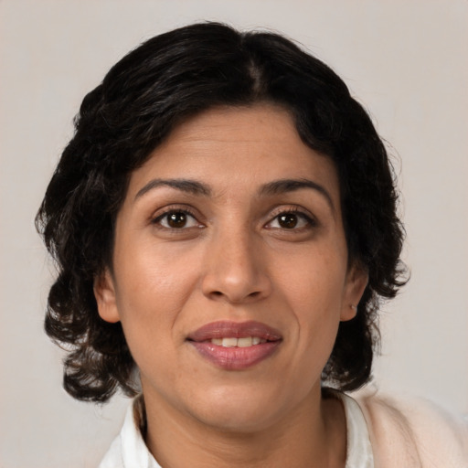 Joyful latino adult female with medium  brown hair and brown eyes