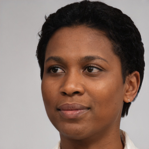Joyful black young-adult female with short  black hair and brown eyes