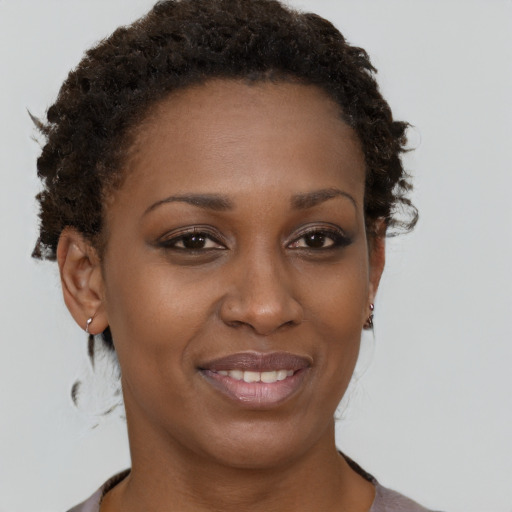 Joyful black young-adult female with short  brown hair and brown eyes