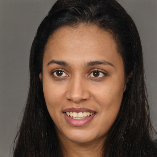 Joyful latino young-adult female with long  brown hair and brown eyes