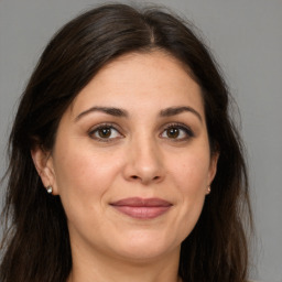 Joyful white adult female with long  brown hair and brown eyes