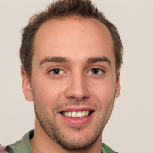 Joyful white young-adult male with short  brown hair and green eyes