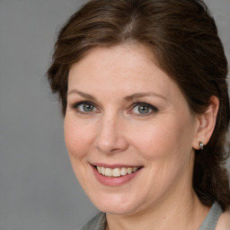 Joyful white adult female with medium  brown hair and grey eyes