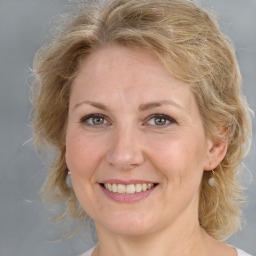 Joyful white adult female with medium  brown hair and grey eyes