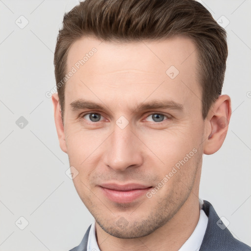 Joyful white young-adult male with short  brown hair and grey eyes