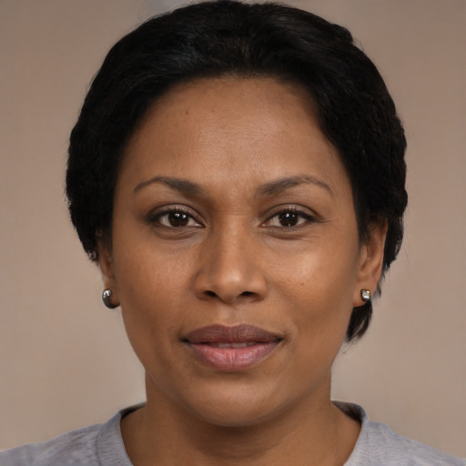 Joyful black adult female with short  black hair and brown eyes