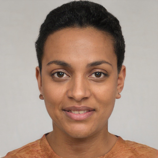 Joyful black young-adult female with short  black hair and brown eyes