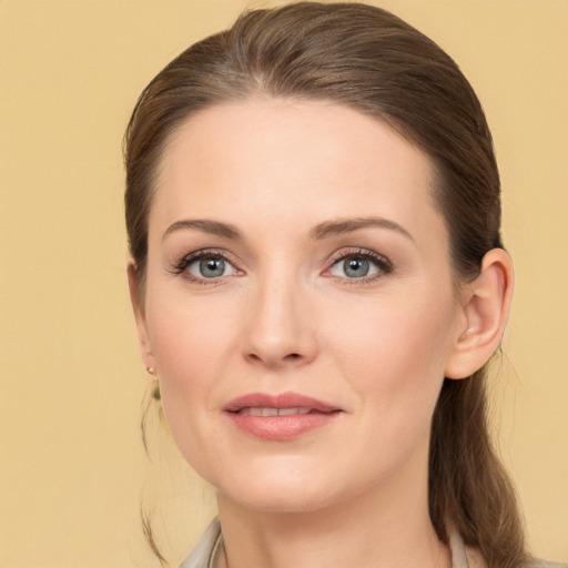 Joyful white young-adult female with medium  brown hair and grey eyes