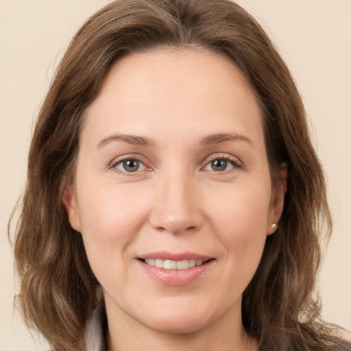 Joyful white adult female with long  brown hair and grey eyes